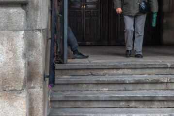 A person begging at the door of a church