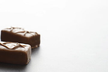Chocolate bars on a black background in backlight. Chocolate with filling. Sweet sweets for snack and tea.
