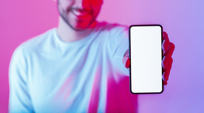 Share joyful information. Smiling man holding smartphone with blank screen