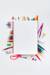 Blank squared notebook on colorful school supplies