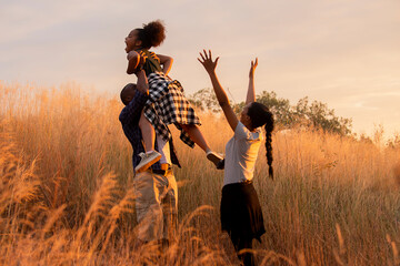 Fototapeta na wymiar african family enjoy together on meadow with sunlight at nature park