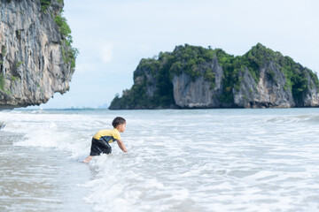Portrait of little boy splashing in ocean waves
