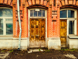 Closed wooden door of the entrance to the old brick building
