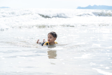 Portrait of little boy splashing in ocean waves
