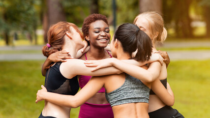 Fototapeta premium Multinational women embracing after morning yoga training at park