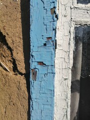 old textures - dried blue and white paint, clay. adobe house close-up. paint cracked