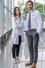 Medical Staff Having Discussion In Modern Hospital Corridor.