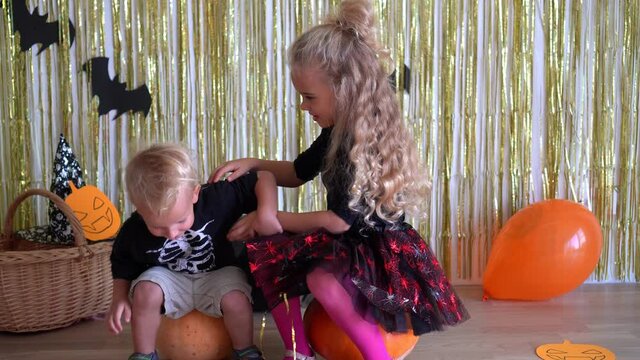 Happy loving children playing in Halloween decorated room at home