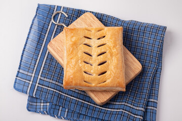 Square pie on a wooden chopping block