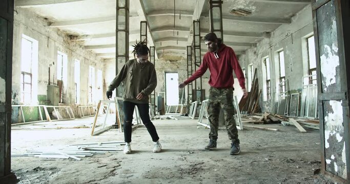 The terrifying zombie guys walking around the abandoned house. Creepy undead man hanging out and dancing at the Halloween party. Supernatural, virus, pandemic concept. Trick or treat.