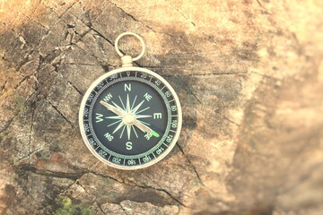 Fototapeta na wymiar round compass on natural wooden background as symbol of tourism with compass, travel with compass and outdoor activities with compass