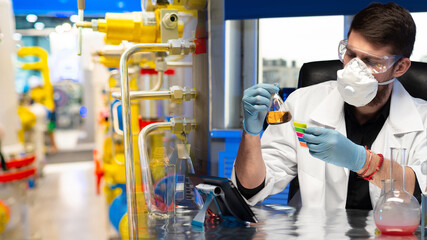 Laboratory assistant in a respirator with test tubes in hands. Concept - Laboratory at the gas...