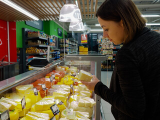 a young woman with a backpack picks up groceries at a grocery store.