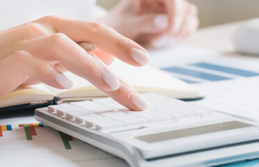 worker using calculator with computer laptop, budget and loan paper in office.