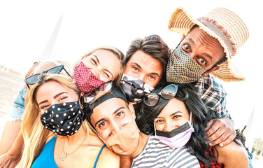 Multiracial milenial friends taking selfie smiling behind face masks - New normal summer friendship...