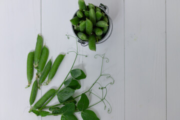 pea pods on a white wooden background, flat lay