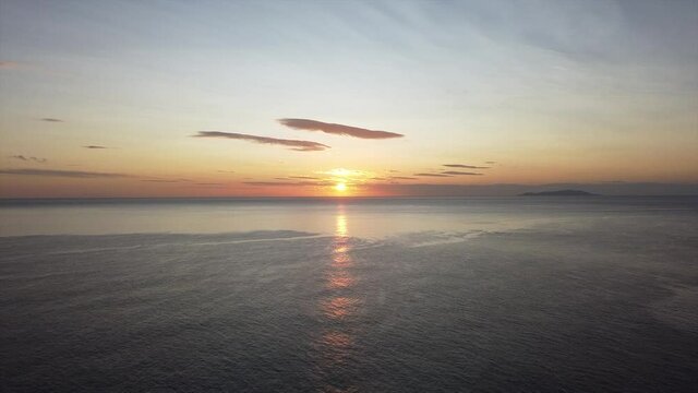steady shot of the sunrise light and the sea silky and waes soft.mov