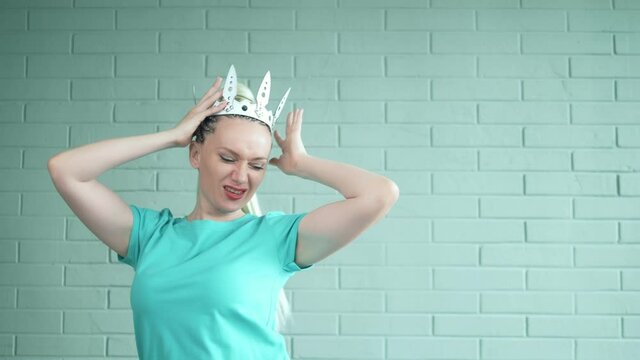 woman blonde with afro braids and a long ponytail puts on a leather white crown