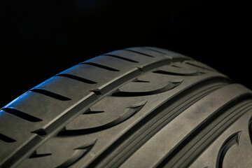 beautiful summer tire tread close up on black background. tread of tire with directional rotation close up