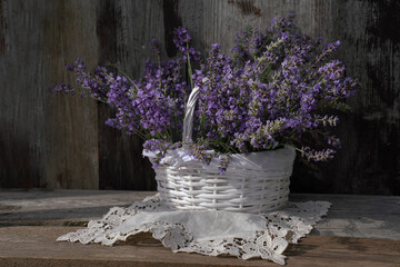 Fresh lavender in wricker basket on wooden desk 