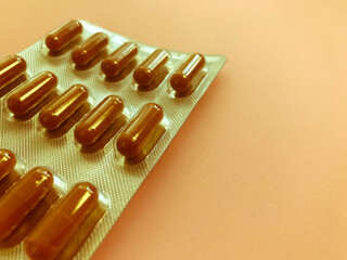 Medical background with bright oval pills in unopened packaging. bright brown herbal medicines to...