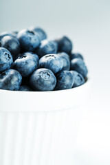 Blueberries in a white Cup on a white background. Isolate, free space