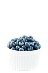 Blueberries are ripe berries in a white Cup on a white background.