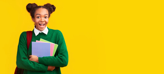 Beautiful young black woman with colorful notebooks at studio