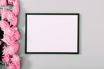 Beautiful flowers composition. Blank frame for text, pink rose flowers on gray background. Valentines Day, Birthday, Happy Women's Day, Mother's day. Flat lay, top view, copy space