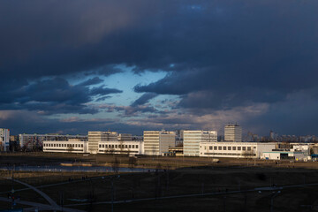 Fototapeta premium dark rain clouds over the city lit by the sun