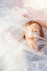 Portrait of beautiful woman in polyethylene wrap. Ecology concept. 