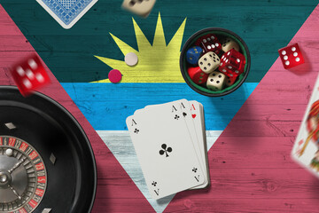Antigua and Barbuda casino theme. Aces in poker game, cards and chips on red table with national flag background. Gambling and betting.