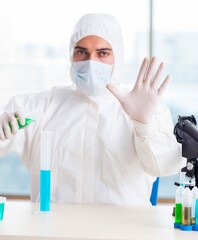 Fototapeta premium Young chemist pressing virtual buttons in lab