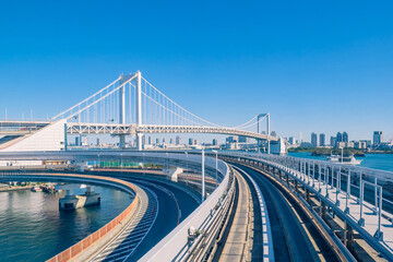 Transport system of Japan. Railway and road bridges in Tokyo. Rainbow bridge in Tokyo Bay. Moving around Japan. The island of Odaiba in the afternoon. Rail, road and water transport.