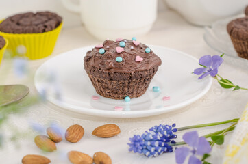Chocolate biscuit muffin with chocolate and sprinkled with hearts on a white background. Valentine's day festive dessert