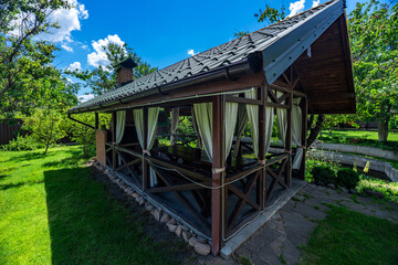 Yard in nature. Beautiful, magnificent view, background and landscape, a panorama of a small wooden gazebo, a veranda in nature, in the hotel, a private villa, on a summer day.