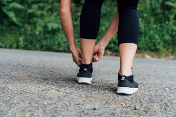 girl tying their shoelaces before going for a run