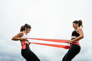 two girls doing fitness with a rubber band