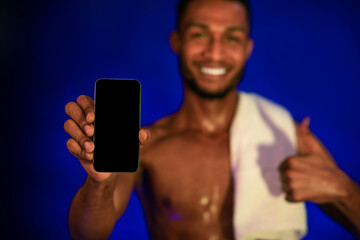 Athlete Guy Showing Smartphone Screen Gesturing Thumbs-Up, Blue Background, Mockup