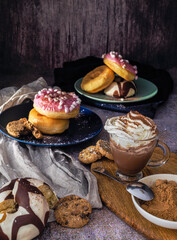 Colored doughnuts with different coverings. Cup of chocolate with cream.