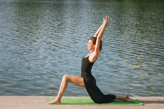 woman practice yoga summer morning by the lake
