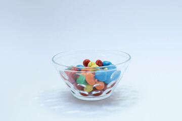 Colorful candy in a bowl on white background
