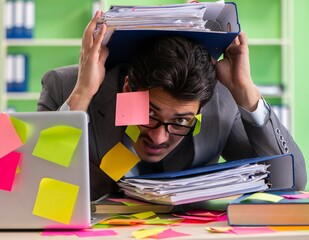 Businessman unhappy with many conflicting priorities sitting in