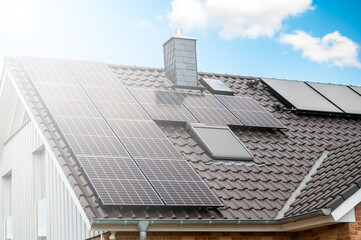 Fototapeta premium Solaranlage auf einem Haus mit Sonne und Lichtreflex
