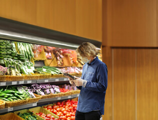 Supermarket shopping, face mask and gloves,man buying vegetables at the market	