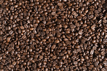Roasted arabica coffee beans background on wooden table.Arabica coffee is the world's most popular type of coffee.