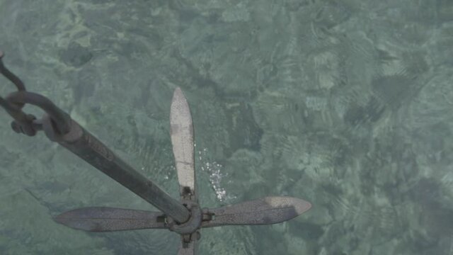 Piccola ancora calata in acqua limpida