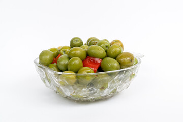 Marinated olives in small transparent bowl. On white background. Pickled green olives