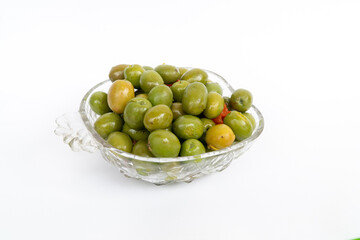 Marinated olives in small transparent bowl. On white background. Pickled green olives