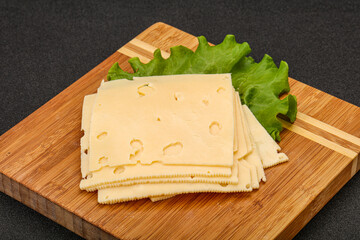 Sliced yellow cheese over board